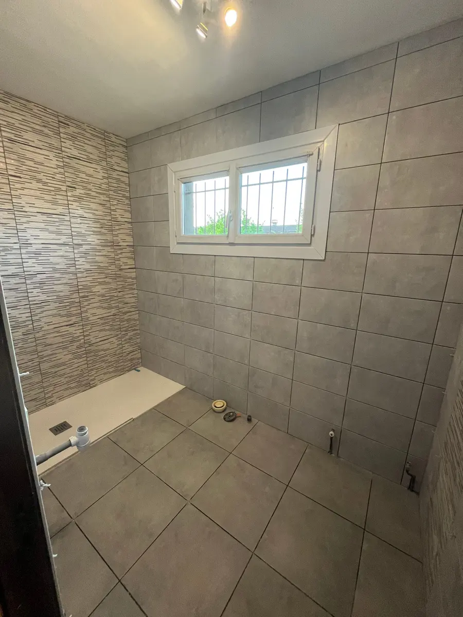 Salle de bain après rénovation par LEMY RENOVATION : douche à l'italienne et parement pierre