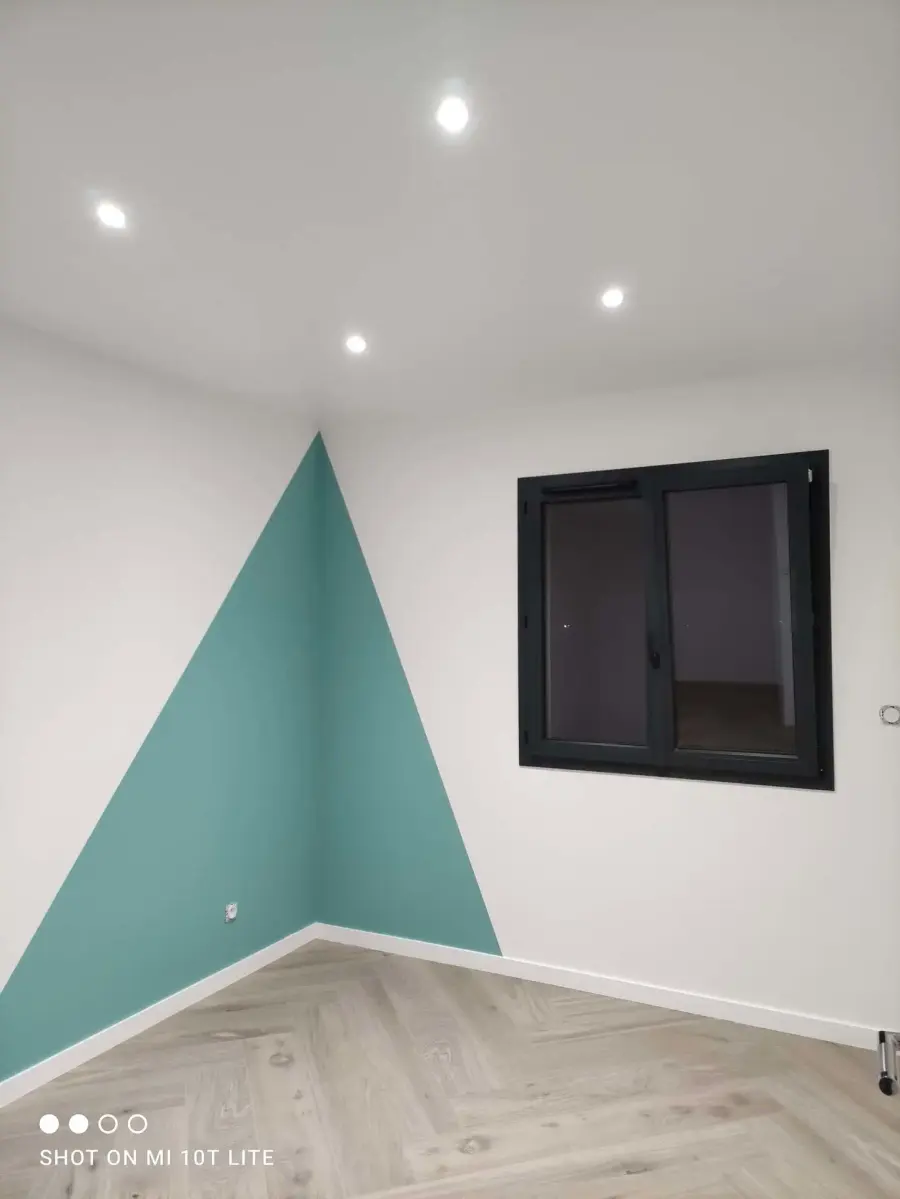 Chambre repeinte en blanc avec un motif géométrique vert